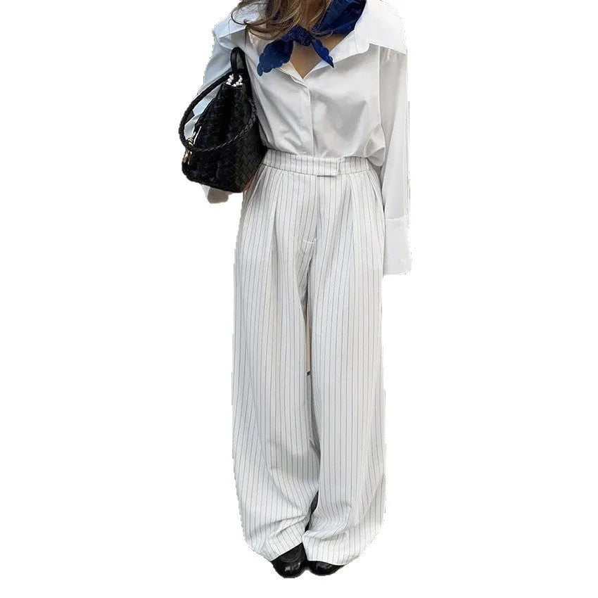 White striped wide-leg casual trousers with a zipper detail on a hanger.