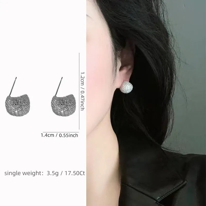 Geometric drop-shaped ear clips with spherical elements in gold and white colour options