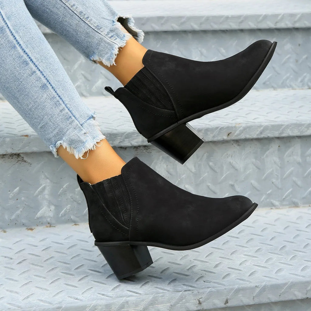 Black women's slip-on ankle boots with a pointed toe and thick square heel on a rubber sole.