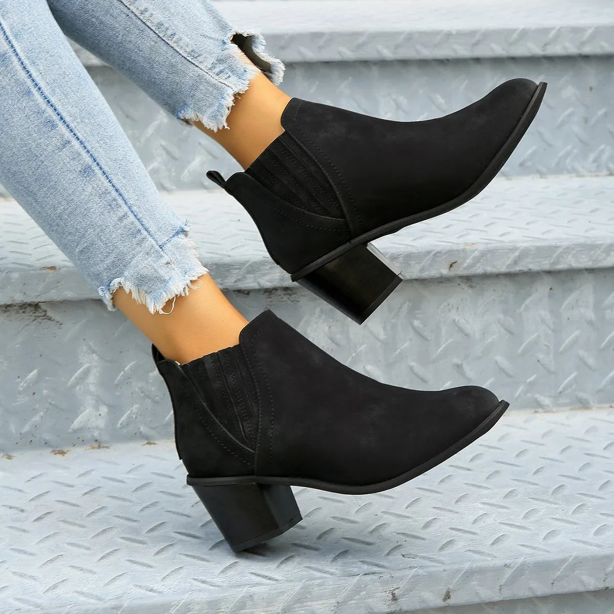 Black women's slip-on ankle boots with a pointed toe and thick square heel on a rubber sole.