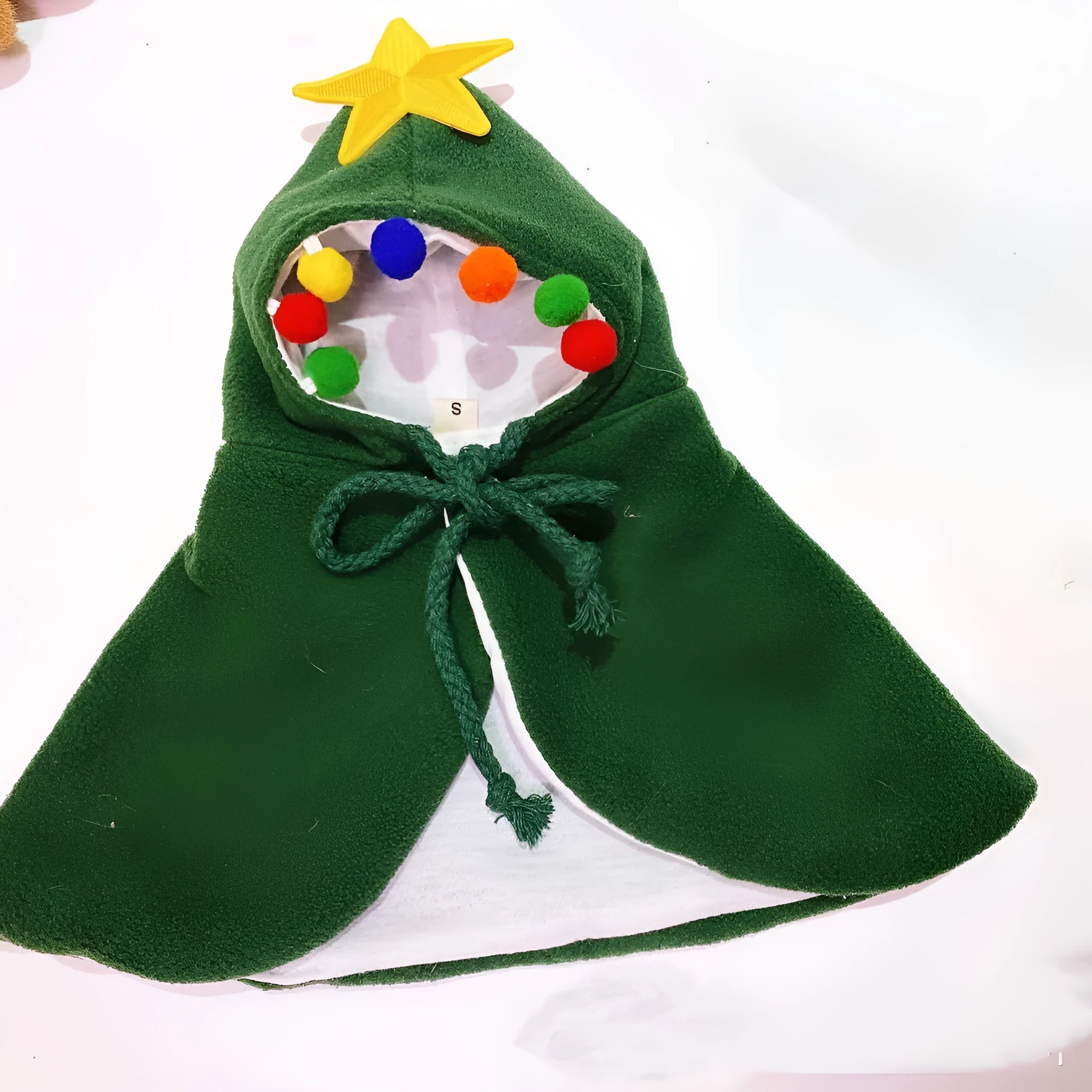 Red Christmas shawl cloak draped on small dog showing cloth fabric and seasonal pet clothing design