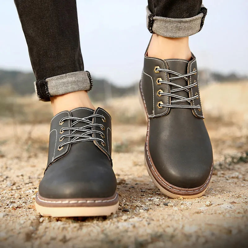 Men's black mid-top leather-look Tide British boots with a flat style and rubber sole.