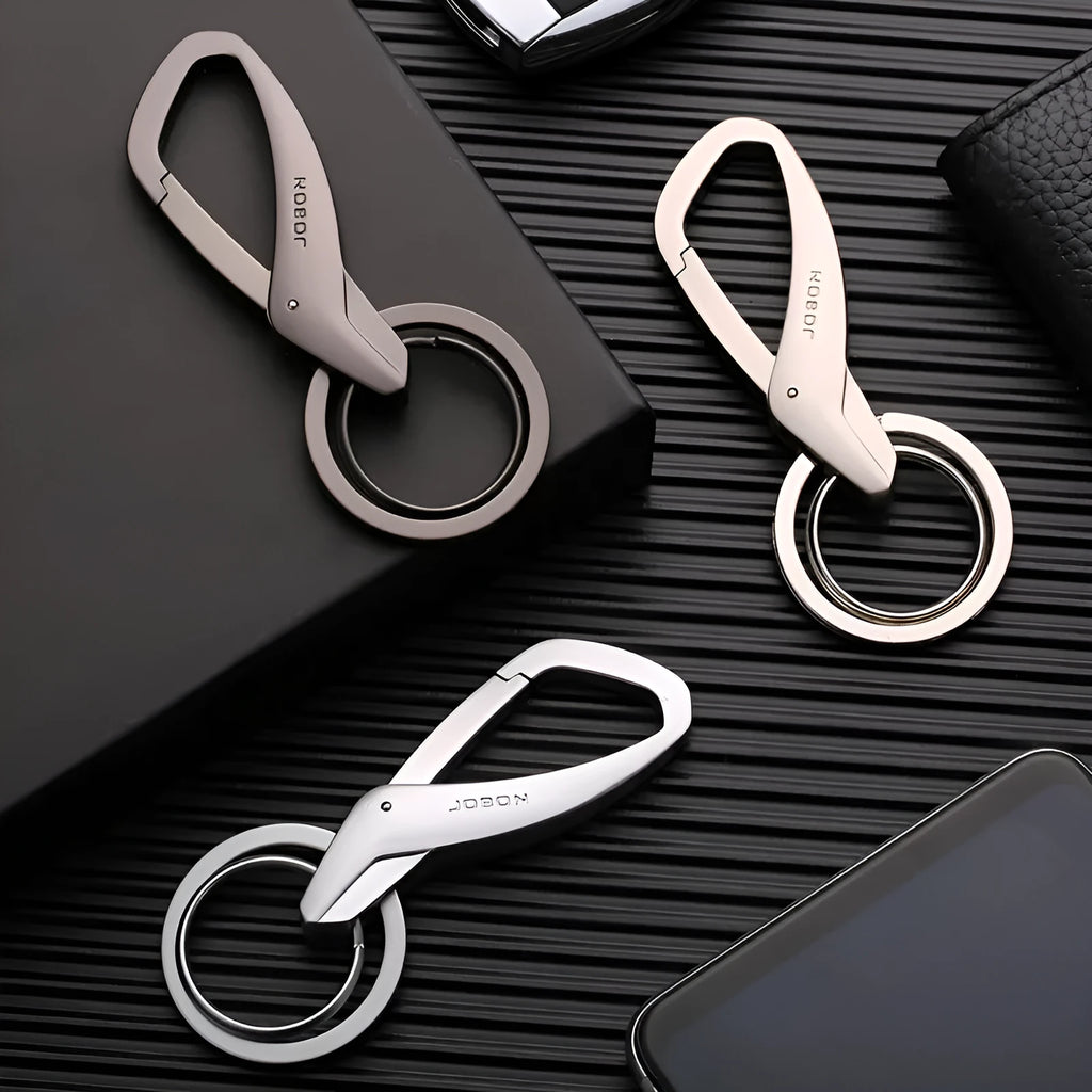 Black zinc alloy keychain with two split rings and a waist clip, shown next to a car key for scale.