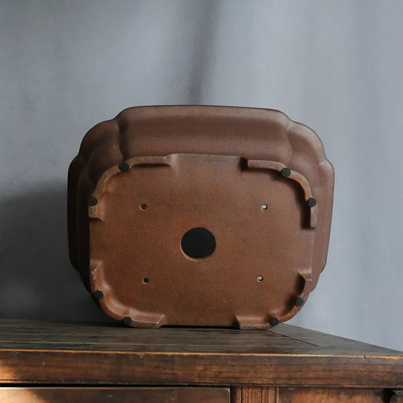 A rectangular purple sand clay bonsai pot on a floor, showing its modern simple design.