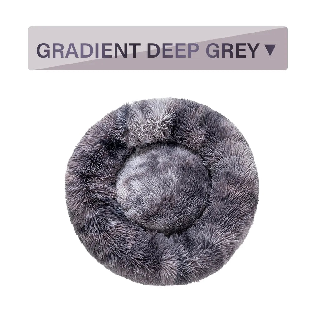 Fluffy grey donut-shaped dog bed with high plush sides on a wooden floor.