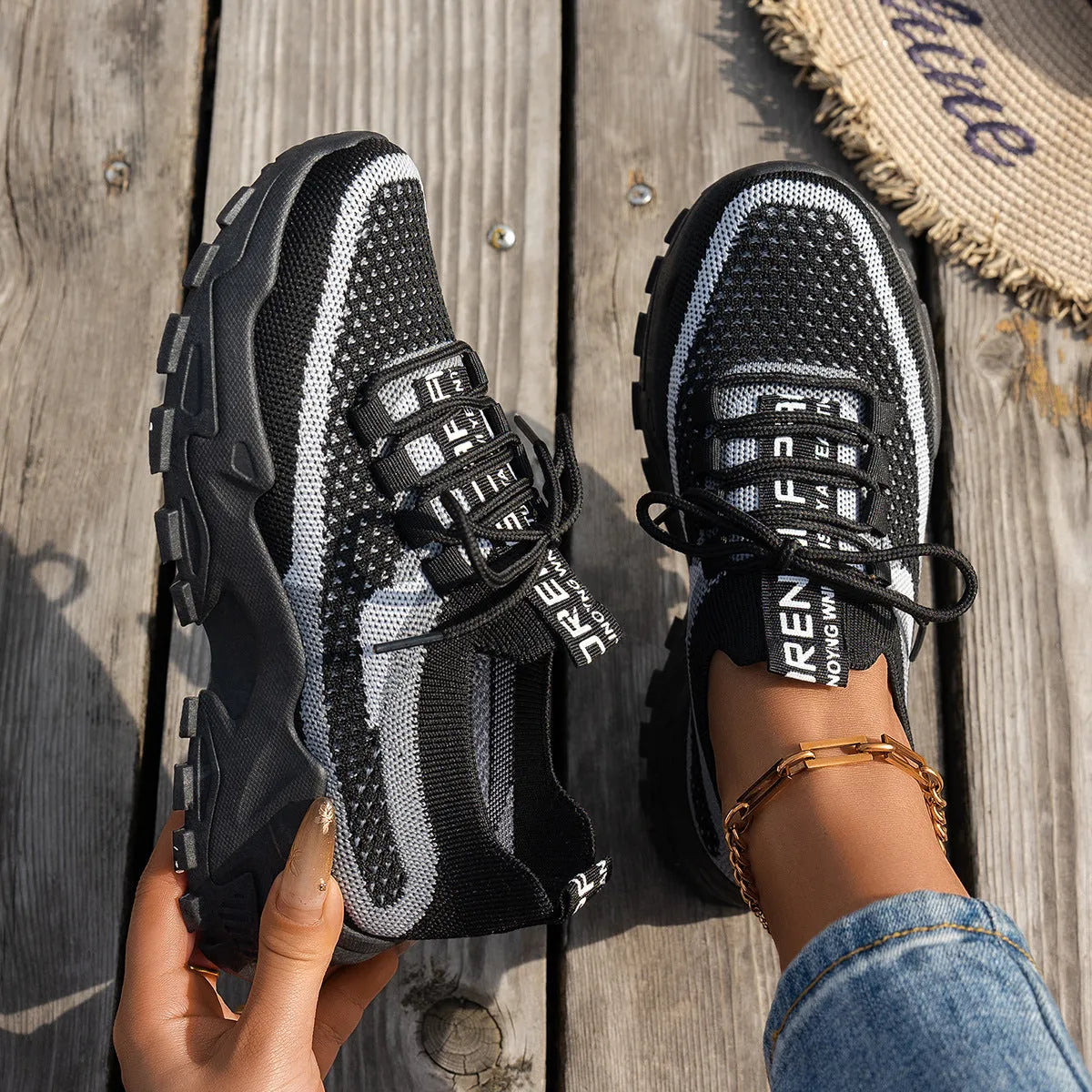 Women's Flyknit mesh lace-up sneakers in grey and white with a low rubber sole.