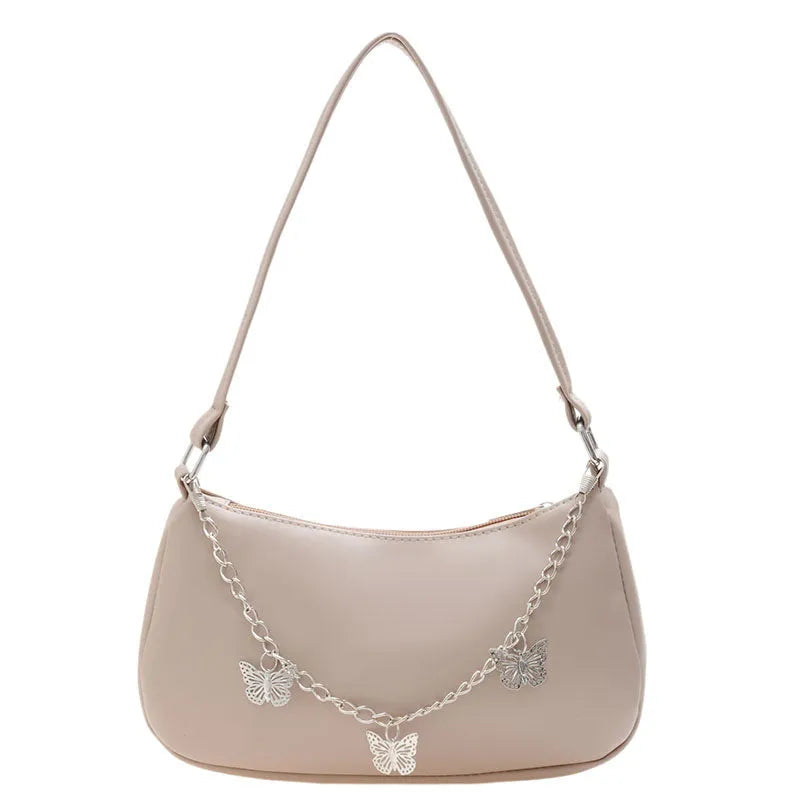 Women's black PU leather butterfly chain underarm bag showing crossbody wear with retro styling