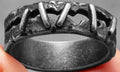 Dark punk style stainless steel ring with a textured stitch pattern and double band.