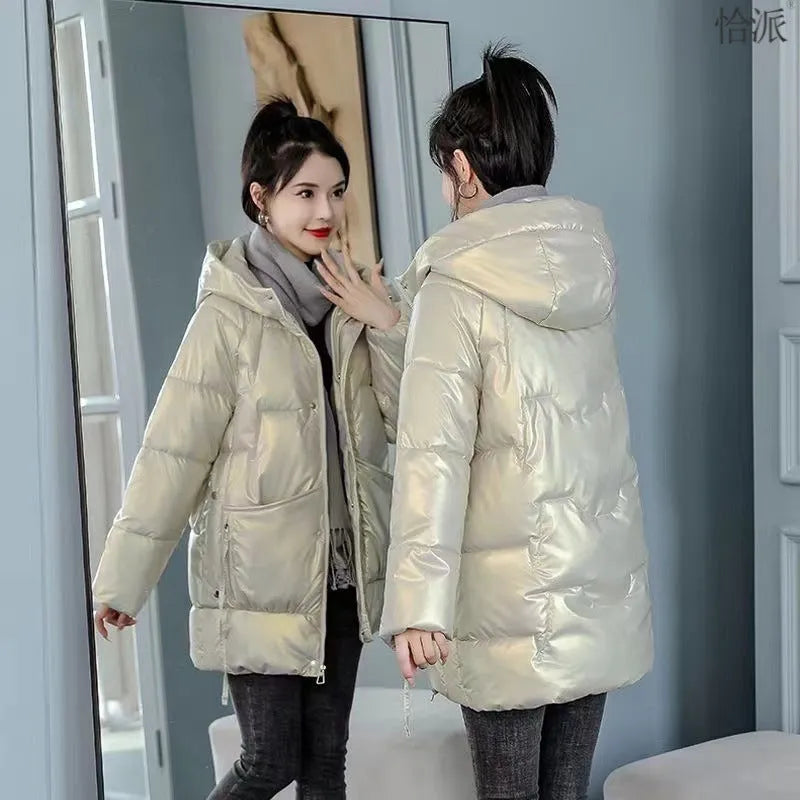 Women's loose fit hooded winter jacket in black, shown on a model, featuring a front zip and acrylic lining.