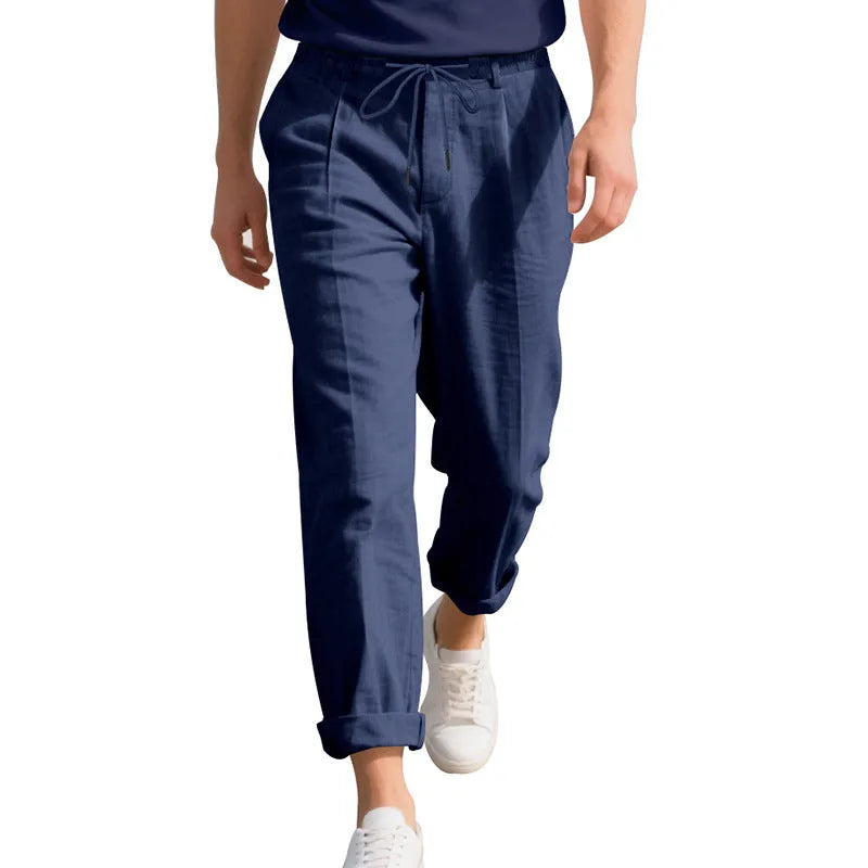 Man wearing light khaki linen casual trousers with a drawstring waist and straight-leg fit.