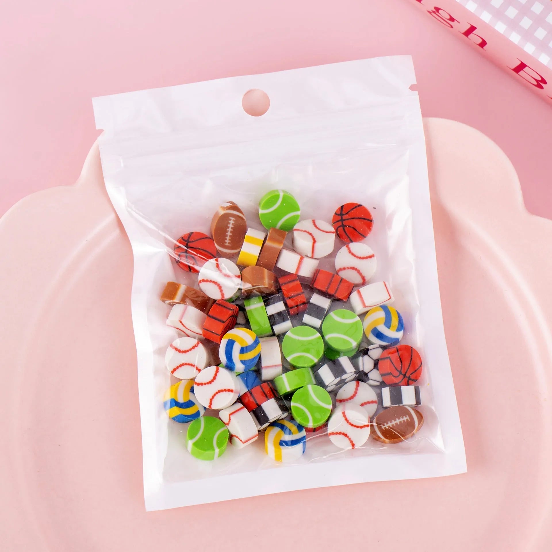 Sealed plastic bag containing 50 small cartoon-themed erasers in shapes like fruits, animals, and Christmas symbols.