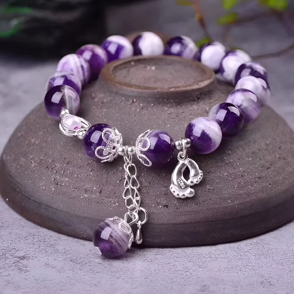 Purple amethyst gemstone bracelet with 10mm round beads on woman's wrist