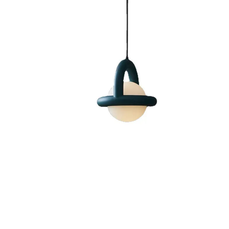 Matte black hanging line lamp with a long black cord suspended above a bedside table.