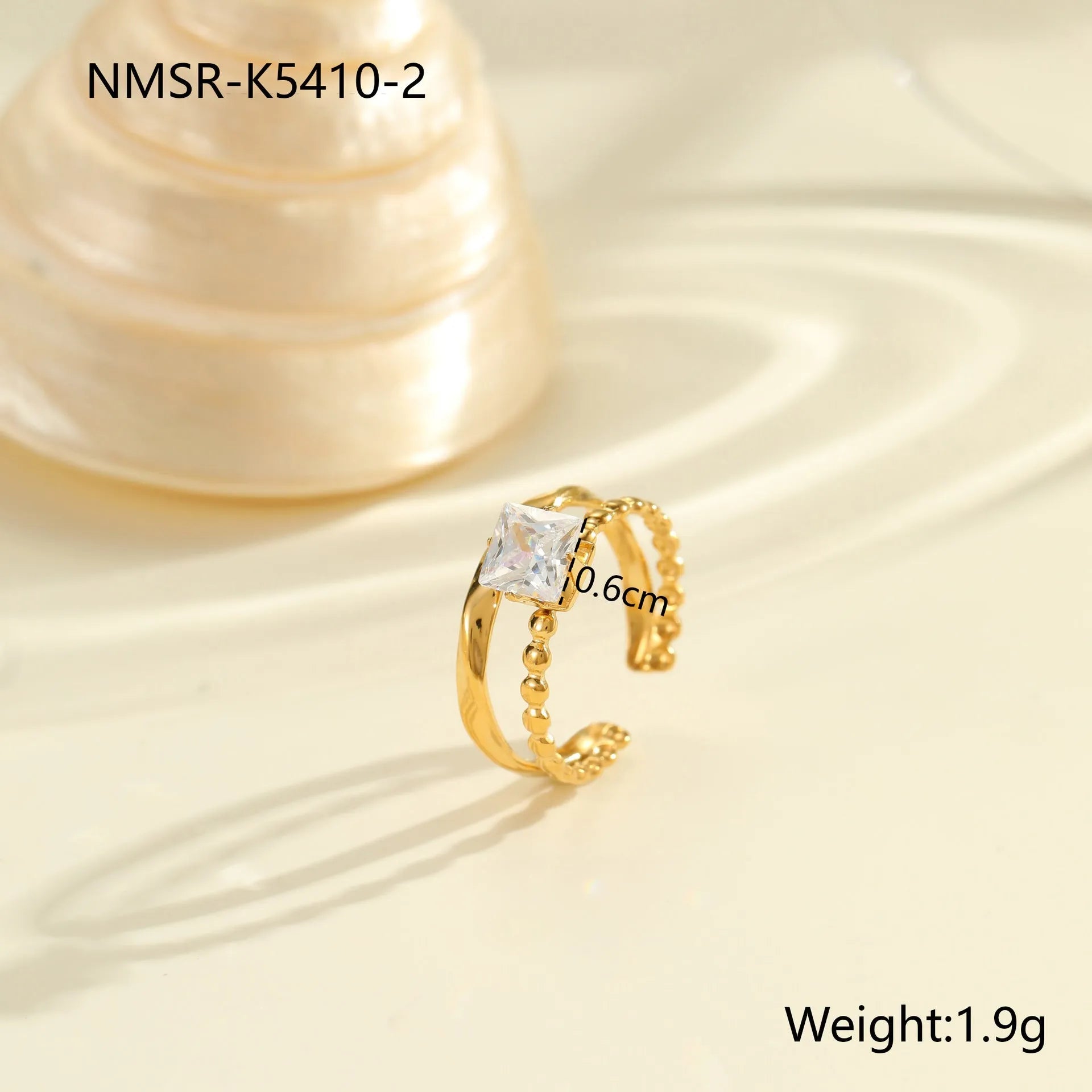 Gold electroplated adjustable ring with geometric zircon design on a stainless steel band.