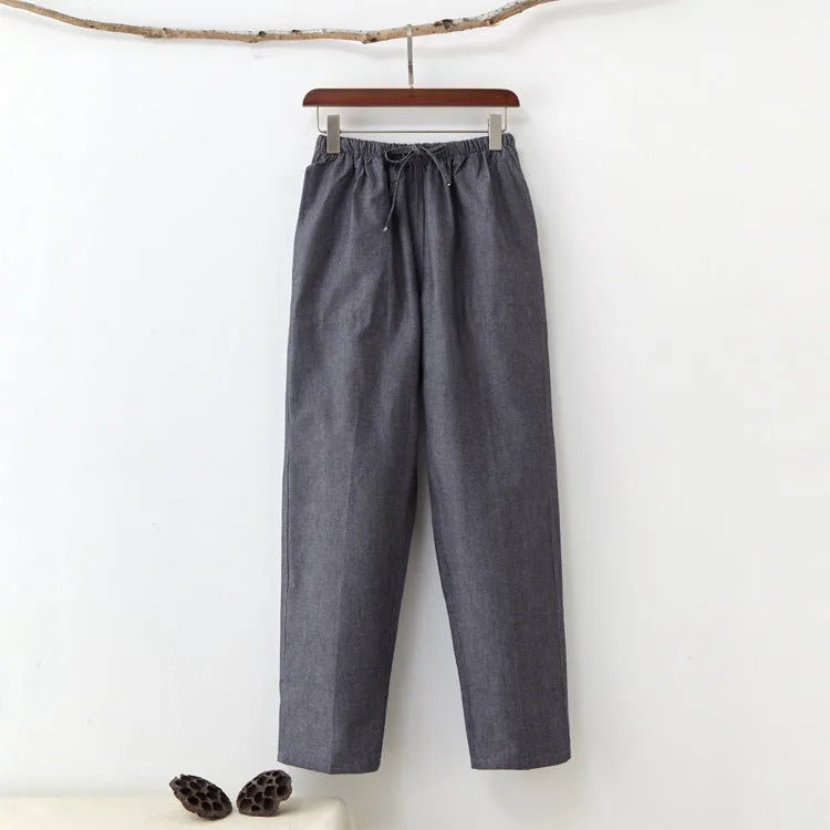 Men's beige pure cotton casual trousers with drawstring waist and belt on a neutral background.