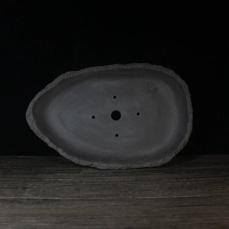 Handmade purple clay flower pot showing natural ceramic texture and floor-standing design