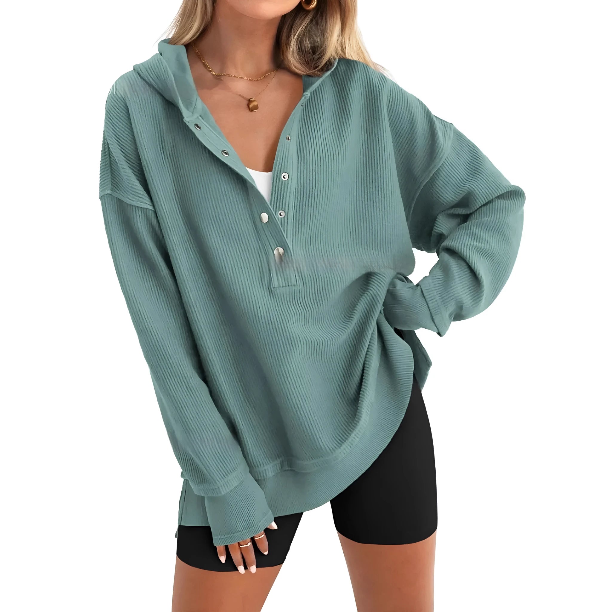 A woman wearing a loose peacock green pullover sweater with raglan sleeves.