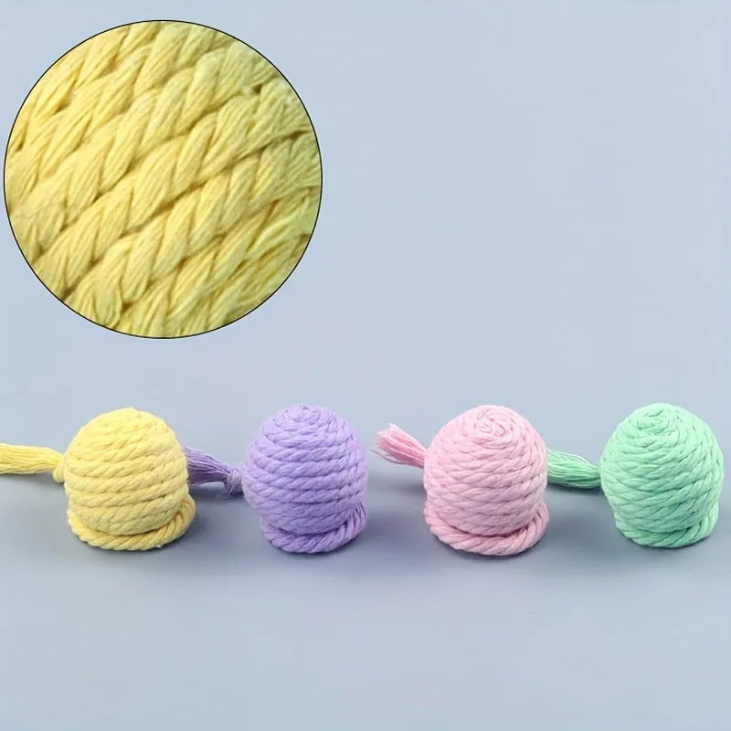 Colourful cat toy ball with an attached rope, shown in green, pink, purple, and yellow.