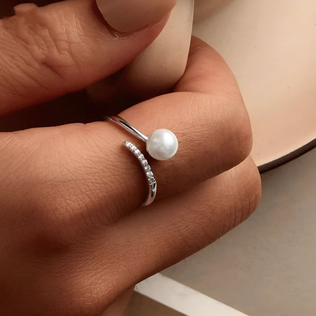 Silver-coloured adjustable open loop ring with a natural white shell pearl setting.
