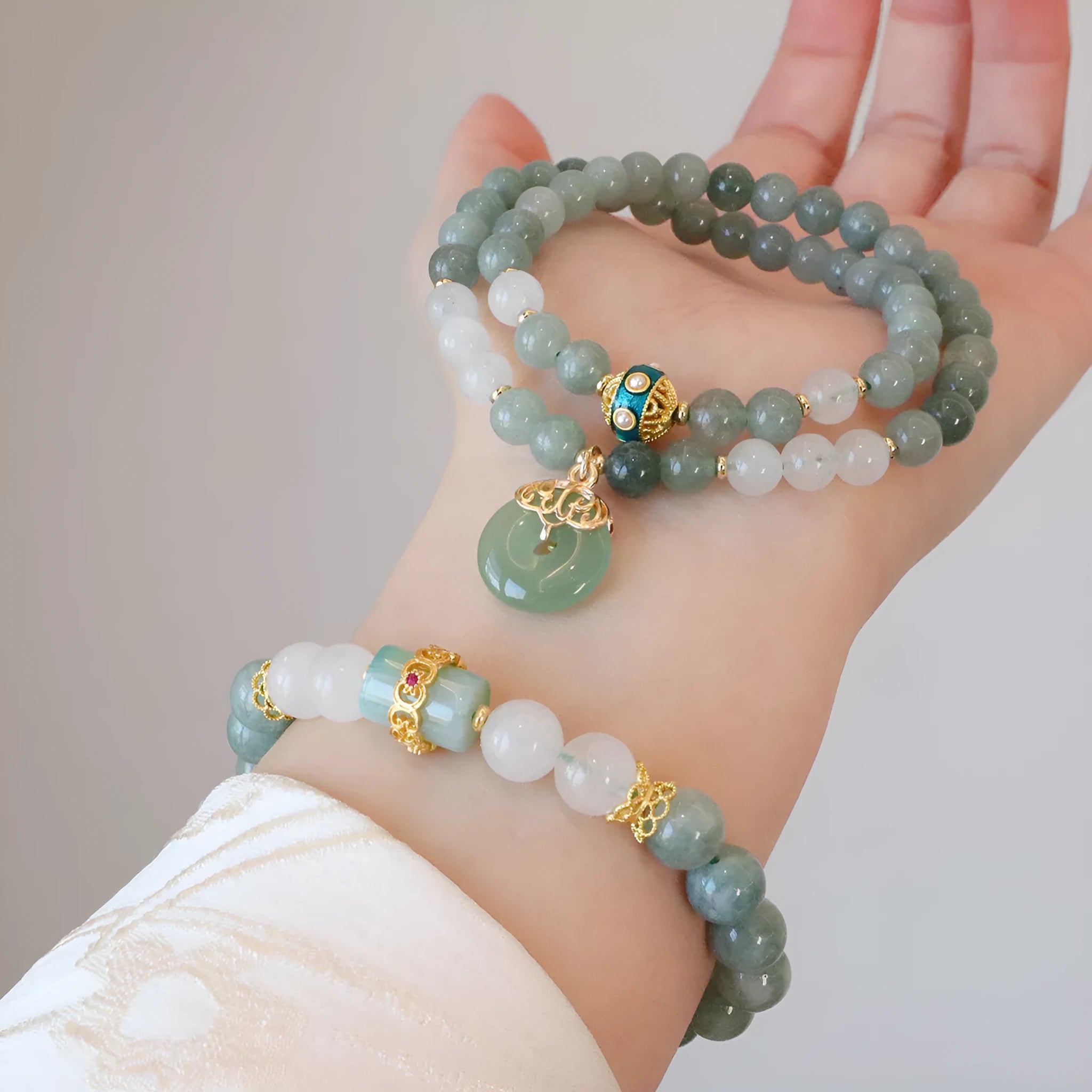 Women's bracelet with a silver peace buckle pendant and green Myanmar jade beads on a black cord.