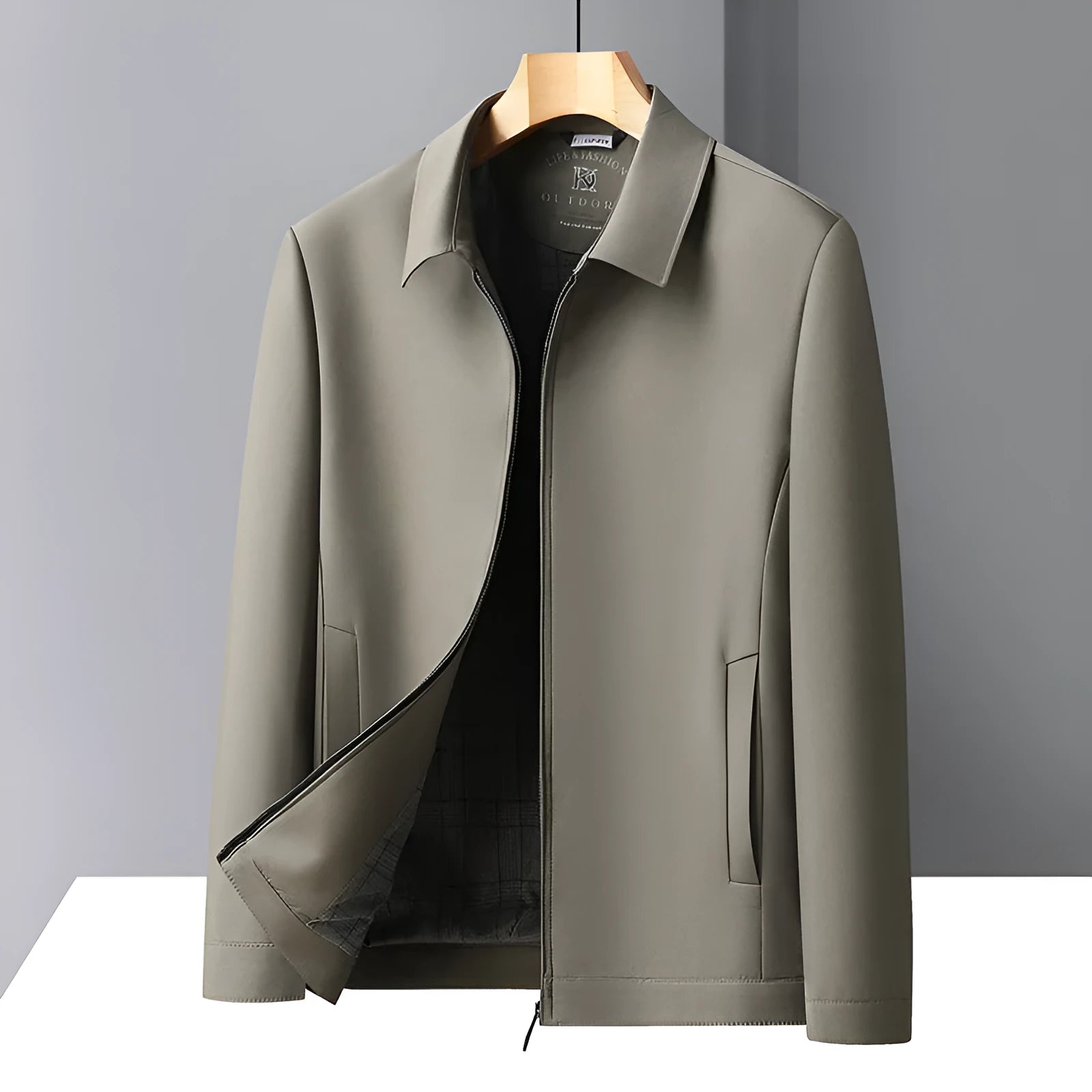 Man wearing a khaki coloured loose-fit polo collar jacket with side seam pockets.