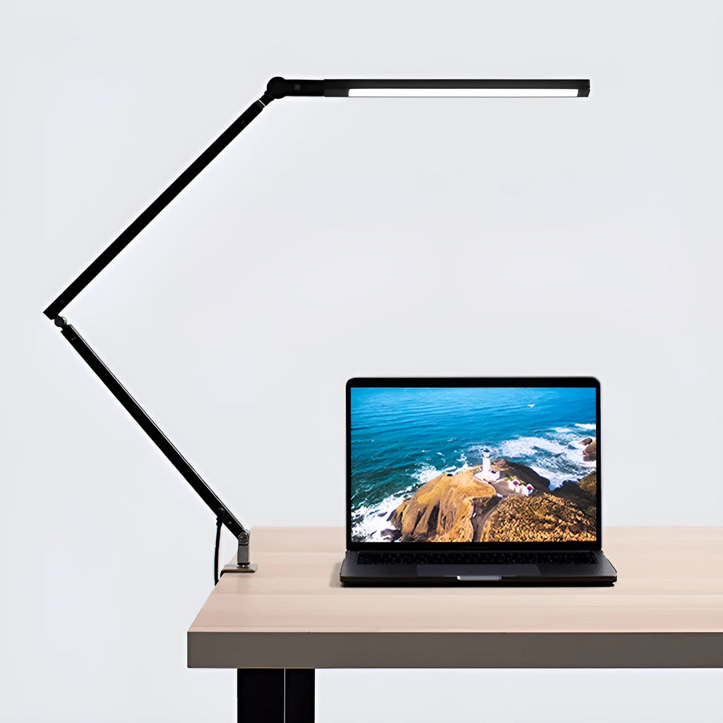 Adjustable LED desk lamp with clip attachment in black finish on wooden desk