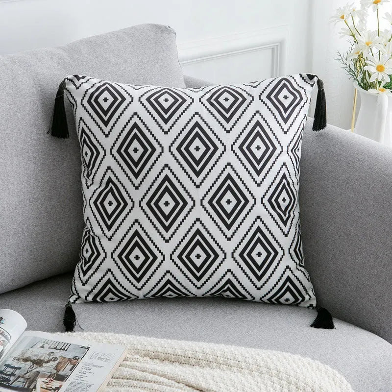 Bohemian style decorative throw pillow with polyester cover in light grey on a sofa.