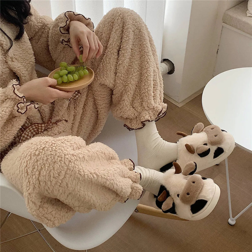 White women's cow slippers with fluffy faux fur, cartoon face, and textured non-slip sole.