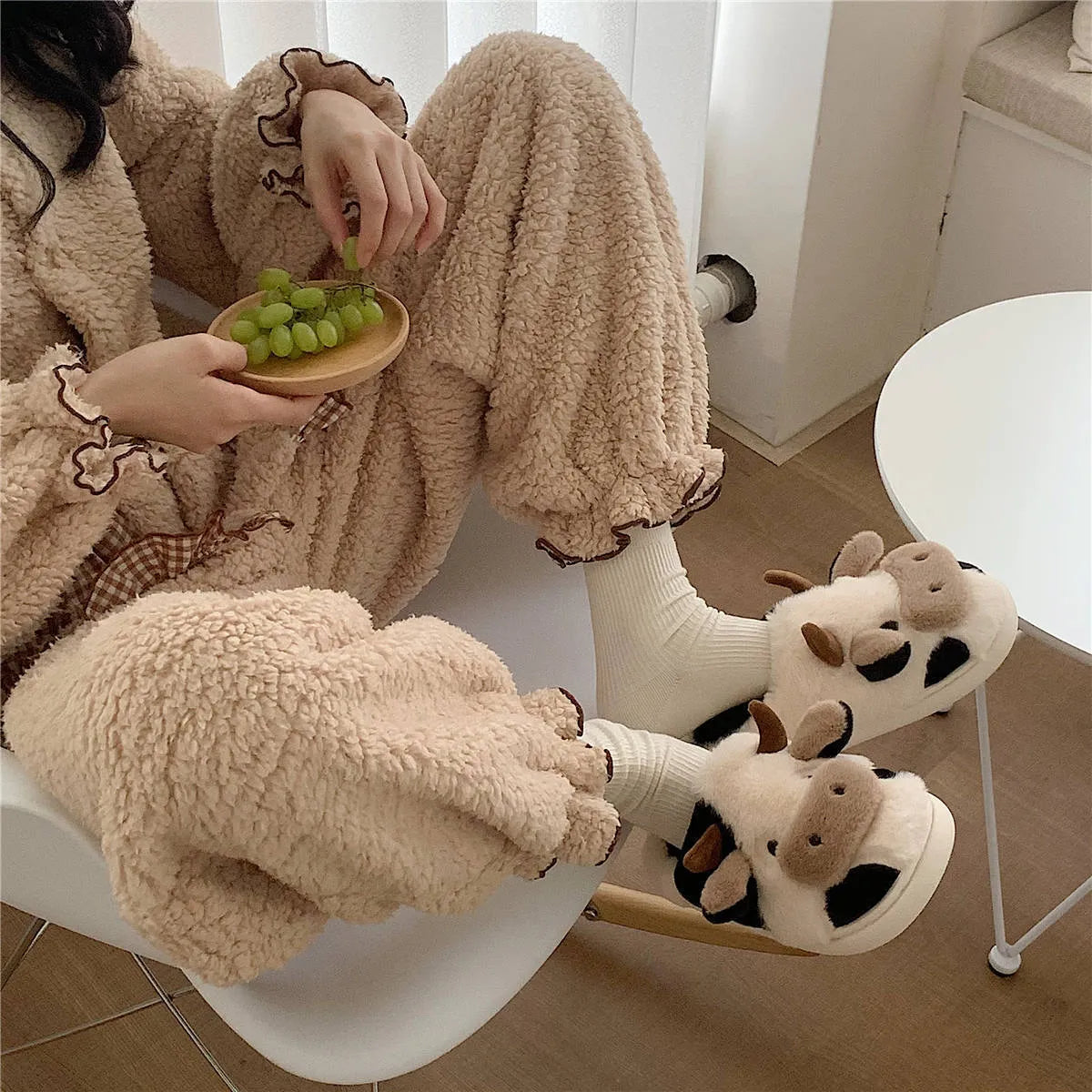 White women's cow slippers with fluffy faux fur, cartoon face, and textured non-slip sole.