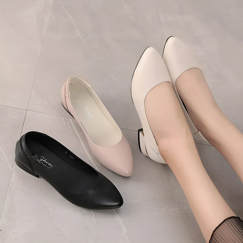 Beige low top casual shoes with pointed toe, buckle fastening, and a thick flat heel.