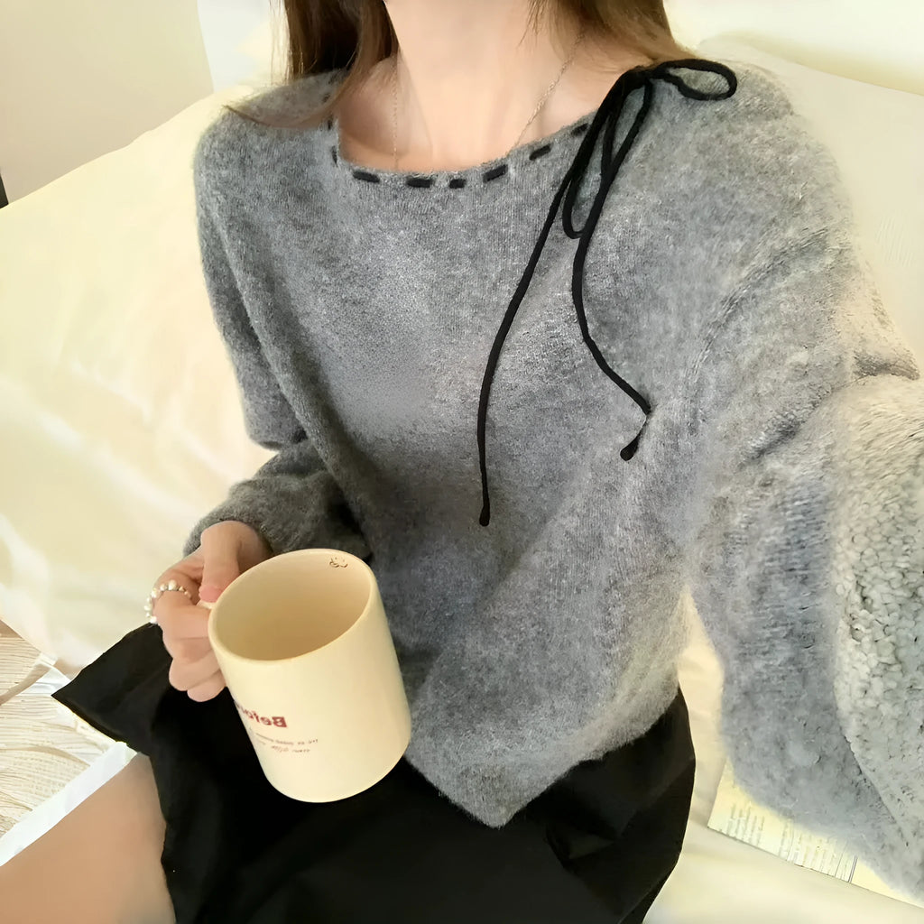 Grey and black versions of a women's loose-fitting pullover jumper made from soft knit fabric.