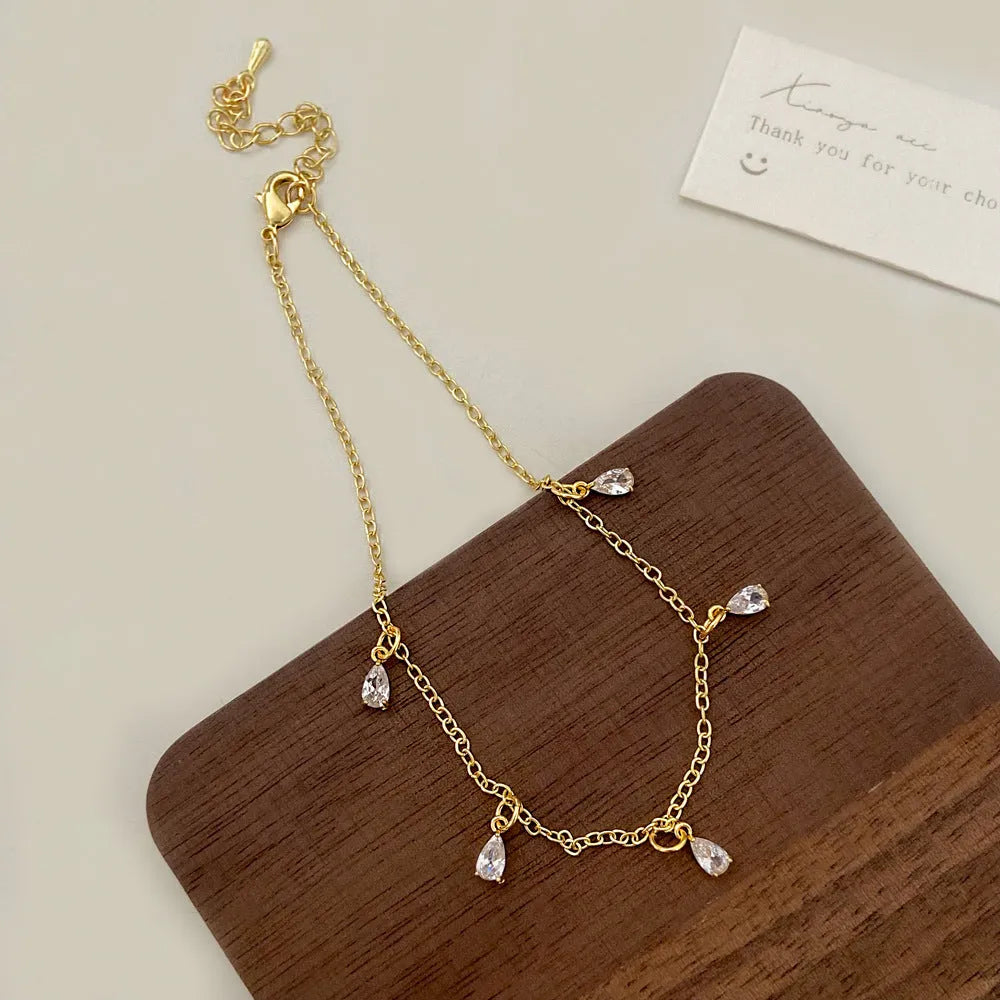 Women's zircon jewellery set showing necklace, earrings, and anklet with geometric meteor shower design.