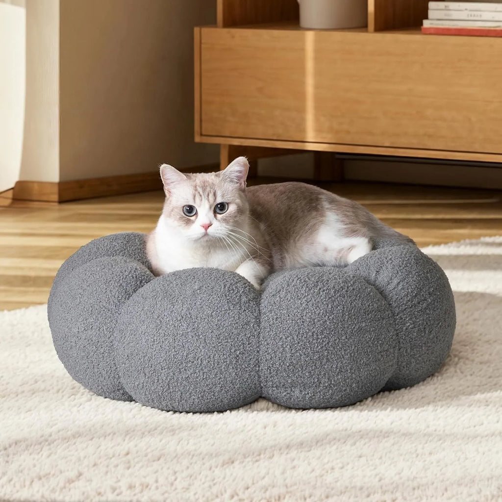 White fluffy flower-shaped pet bed with raised teddy fleece edges and round donut design on a light floor