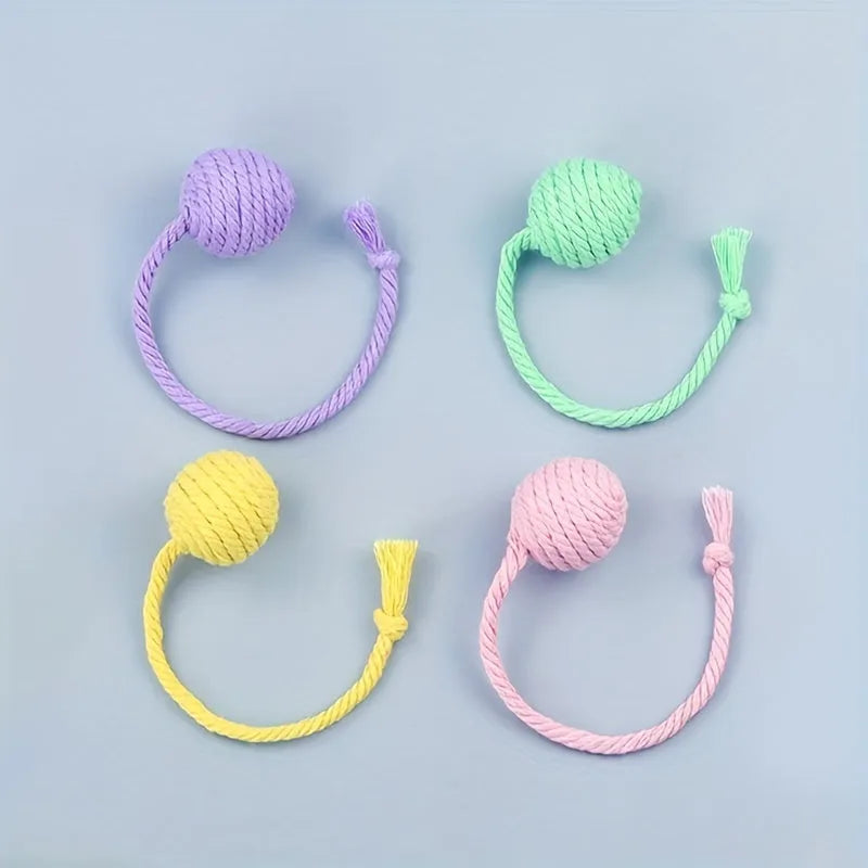 Colourful cat toy ball with an attached rope, shown in green, pink, purple, and yellow.