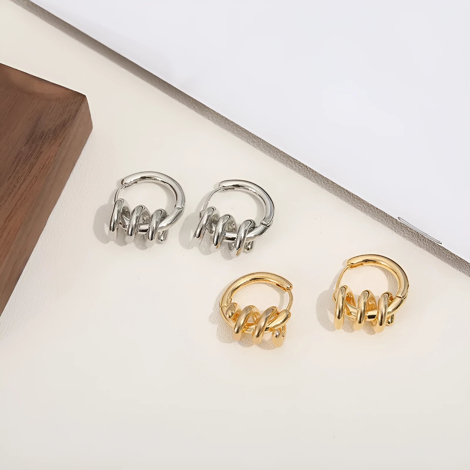 Spiral wound ear clip frosty style geometric earrings in gold colour on white background
