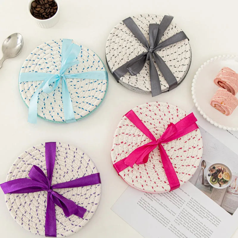 Three round cotton cord coasters in blue, measuring 18cm diameter, on wooden table