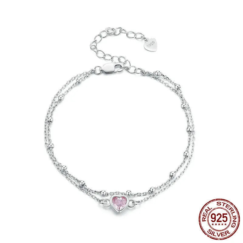 Women's sterling silver bracelet with a small heart-shaped pendant on an adjustable chain.