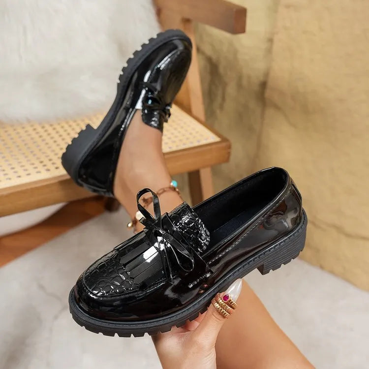 Women's brown and black flat loafers with a bow detail on the artificial PU upper.