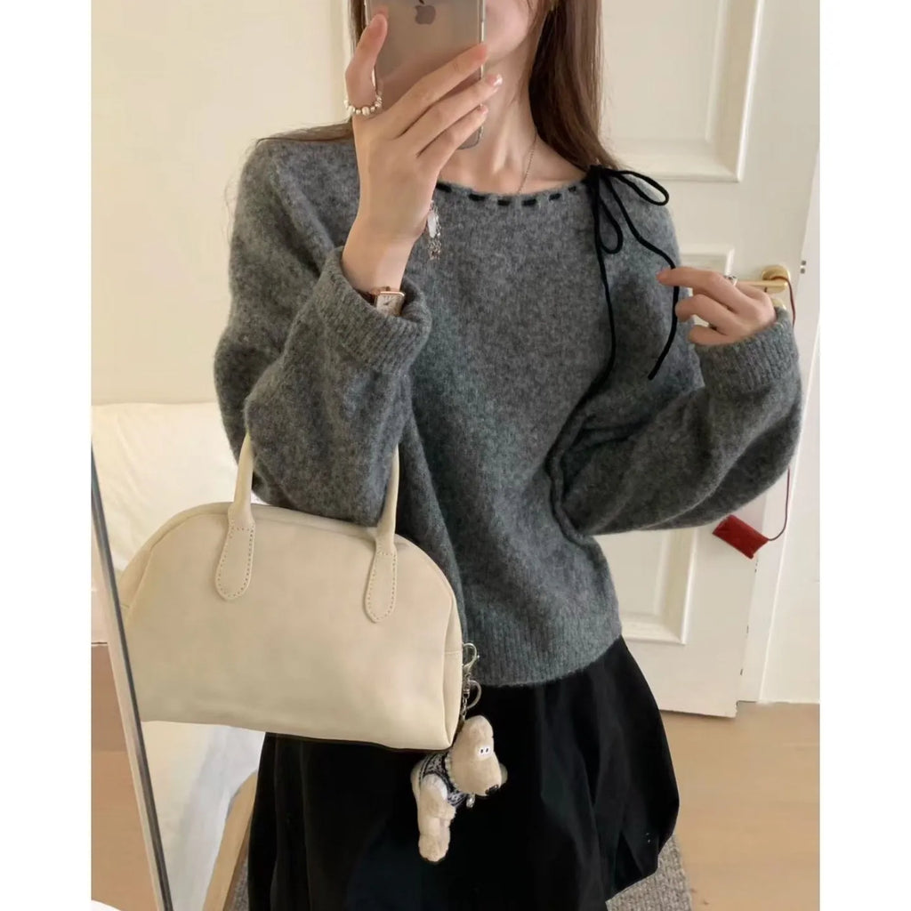 Grey and black versions of a women's loose-fitting pullover jumper made from soft knit fabric.