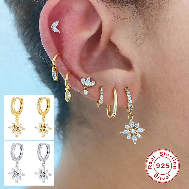 Pair of S925 sterling silver snowflake pendant earrings with gemstone inlay on a white background