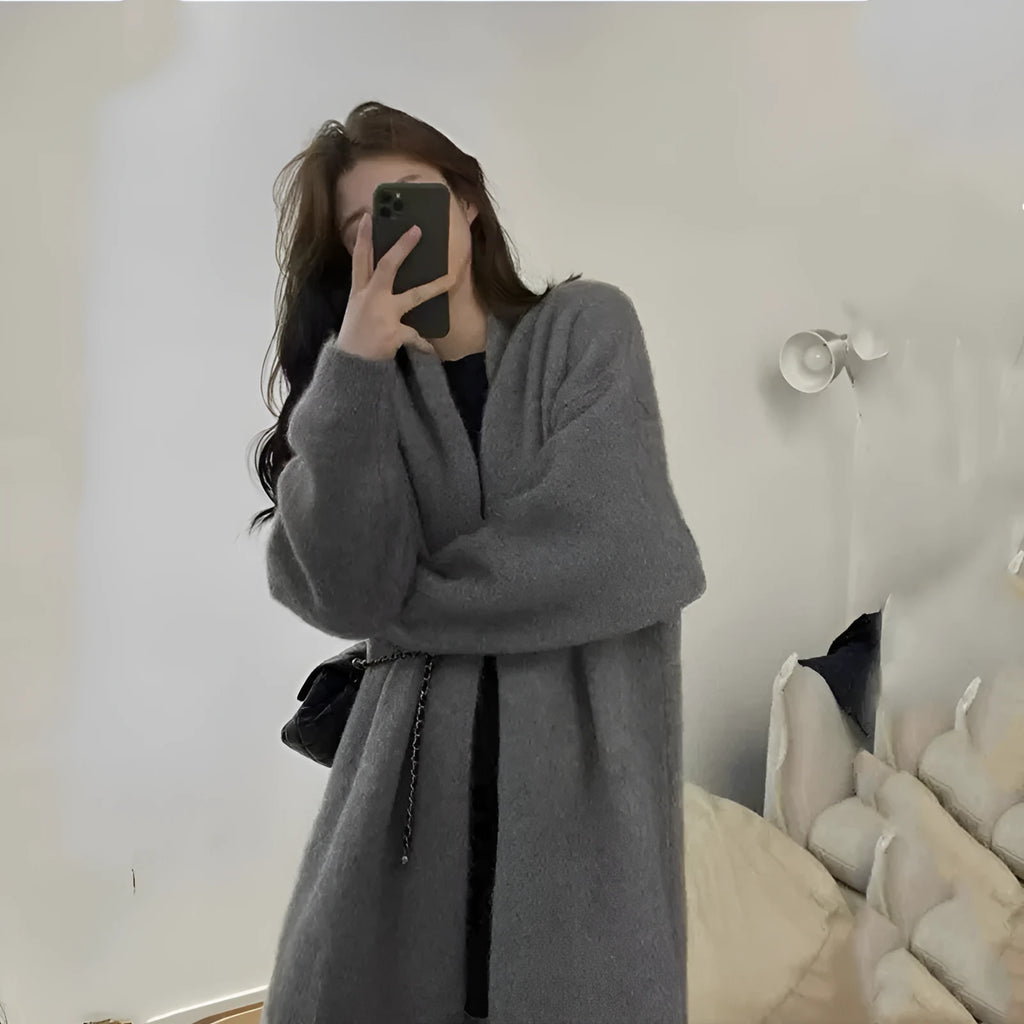 A loose, thick grey knitted women's cardigan with a 3D pattern, shown open as a cardigan.