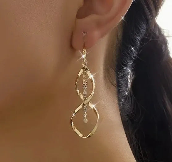 A pair of gold-coloured spiral design earrings with a geometric ellipse shape for women.