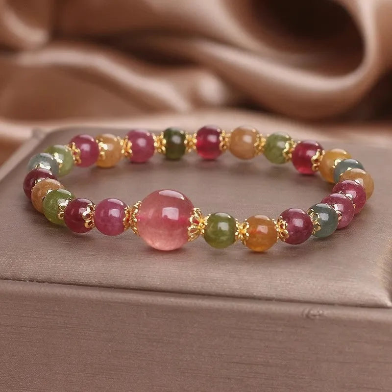 Close-up of a beaded bracelet with round strawberry quartz and tourmaline stones, 10mm in size.