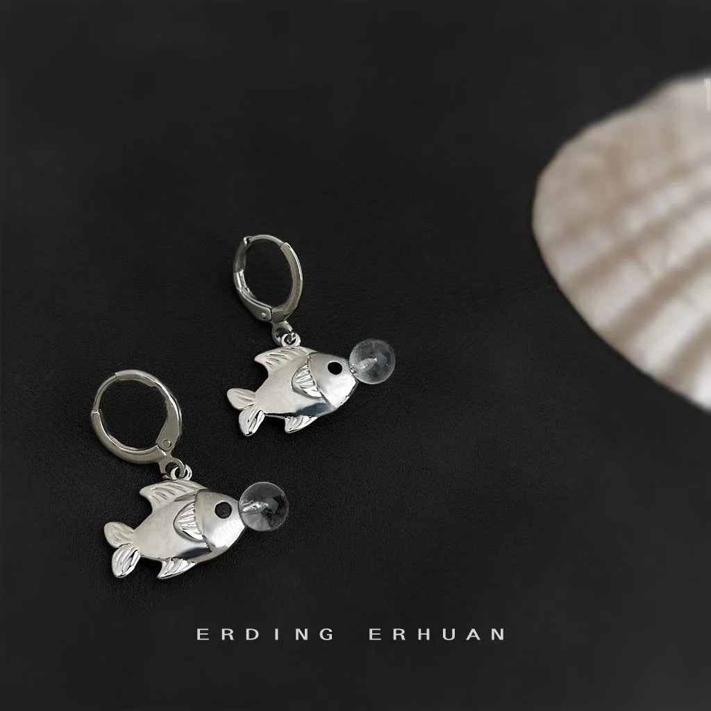 Copper electroplated bubble fish design earrings with goldfish animal modelling on a white background.