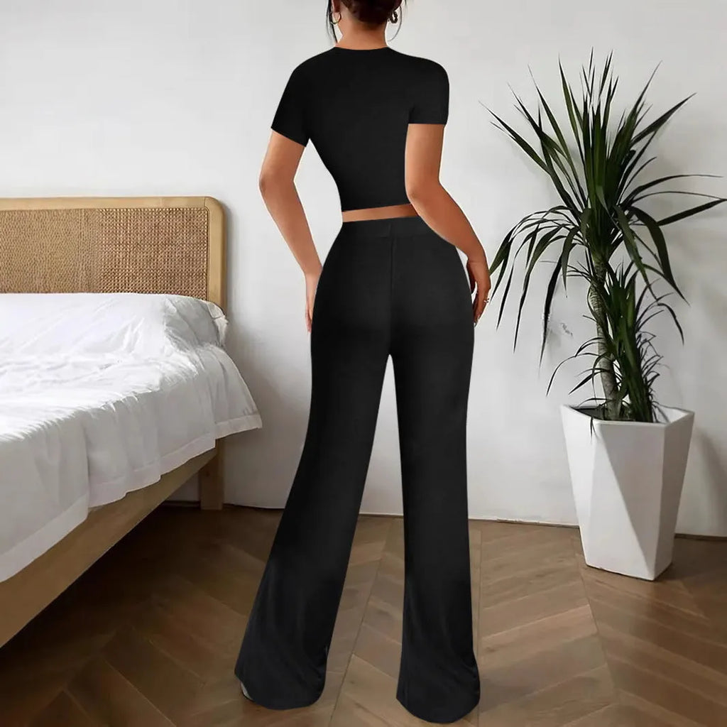 Black high-waist polyester trousers and matching short-sleeve t-shirt laid flat as a two-piece suit set.