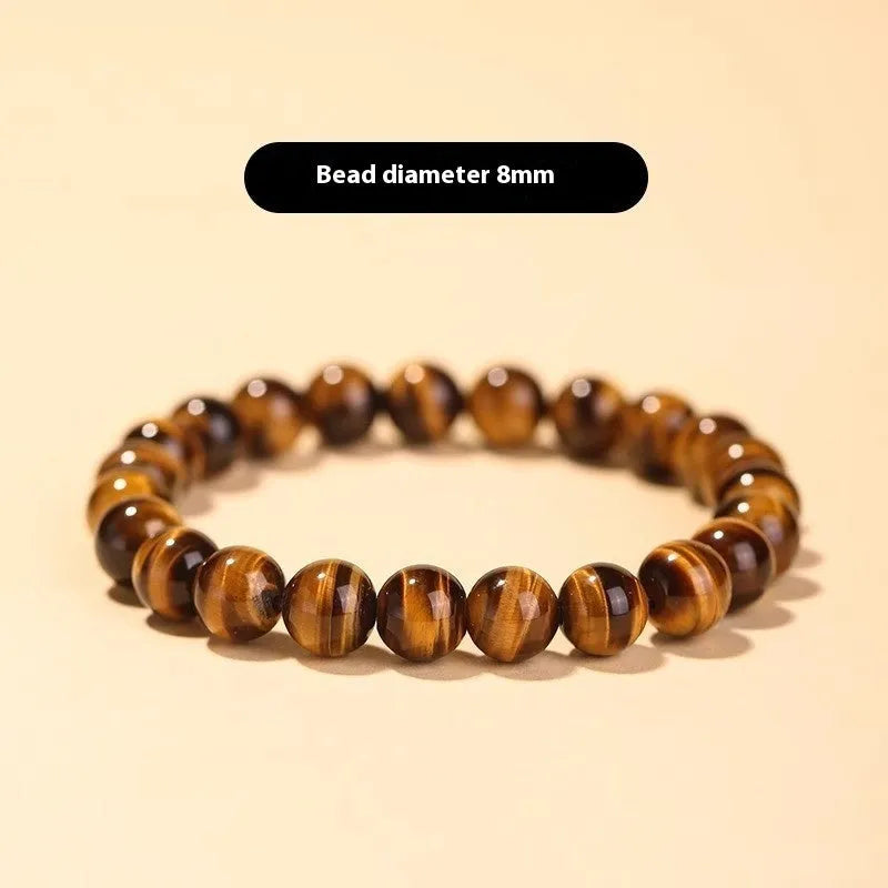 Single circle ethnic Tigereye bead Buddha rosary bracelet on a wrist, showing unisex design.