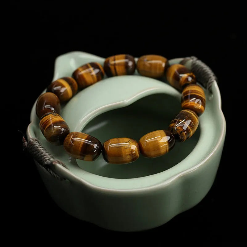 Natural yellow tigereye gemstone bracelet with ethnic constellation design on a wrist.