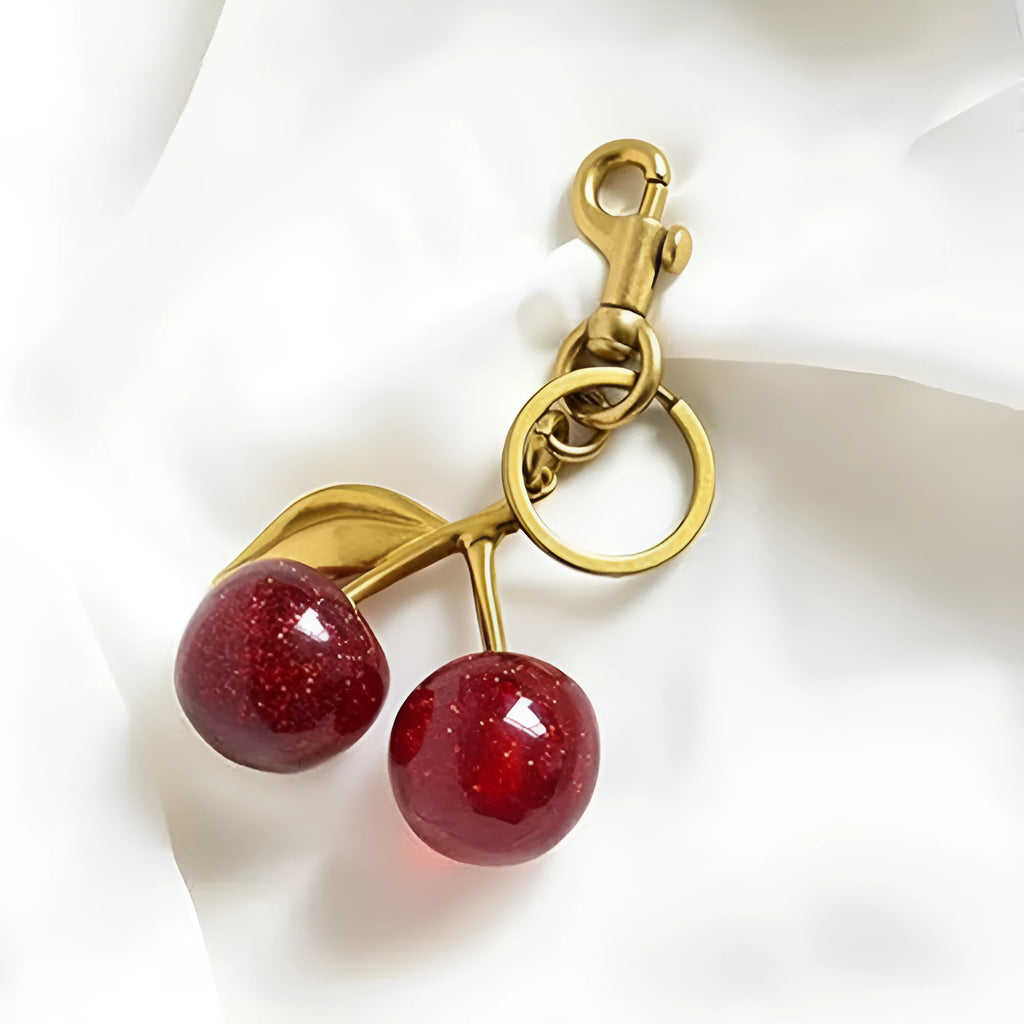 Close-up of a red zinc alloy keychain pendant with a three-dimensional cherry design.