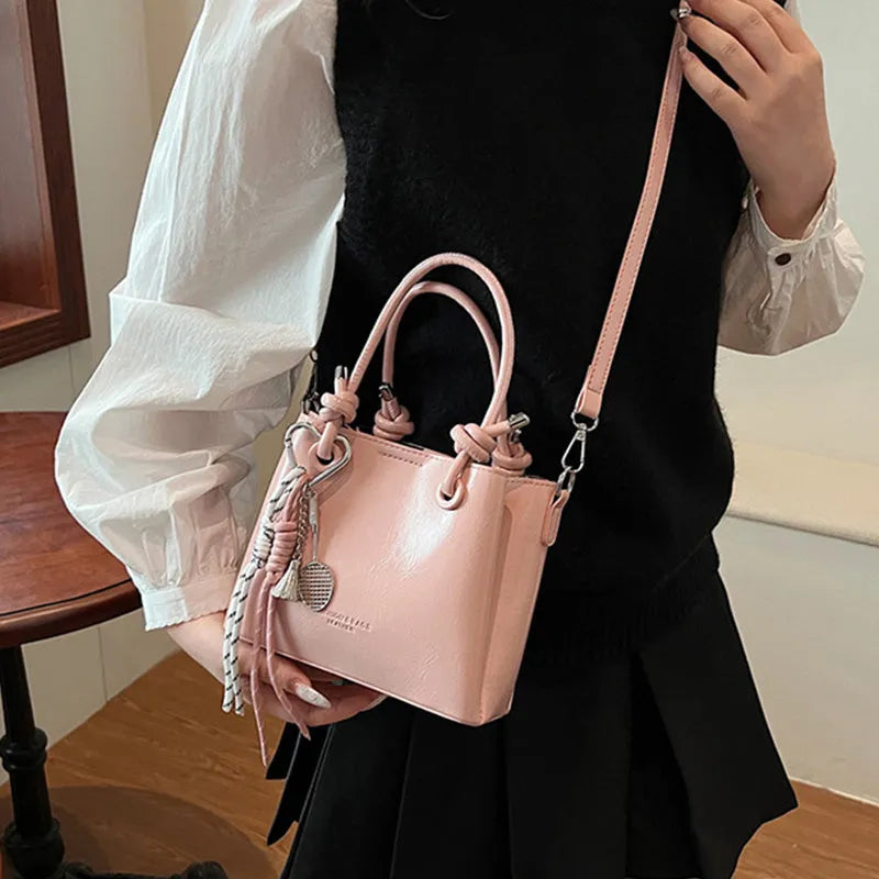 Women's medium-soft PU messenger bag in bucket shape with pendant, black, white, wine red, and pink options