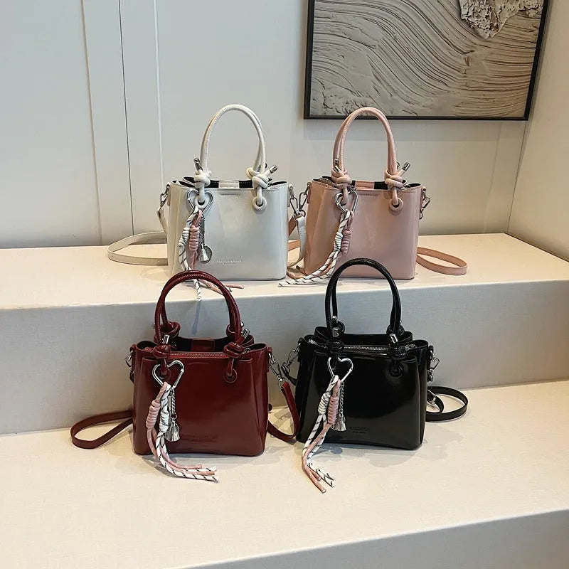 Women's medium-soft PU messenger bag in bucket shape with pendant, black, white, wine red, and pink options
